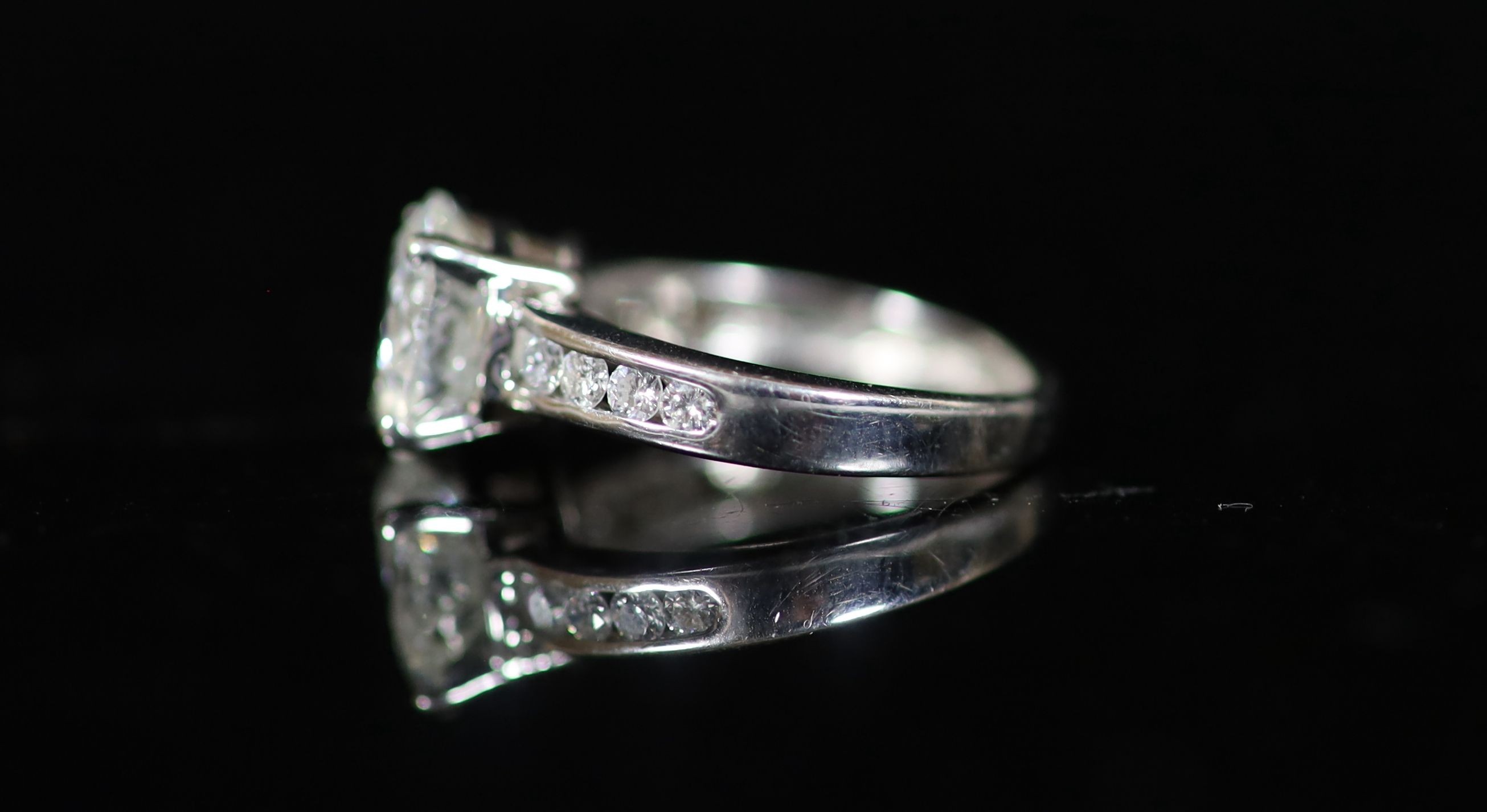 A modern white gold and single stone diamond ring, with eight stone diamond set shoulders